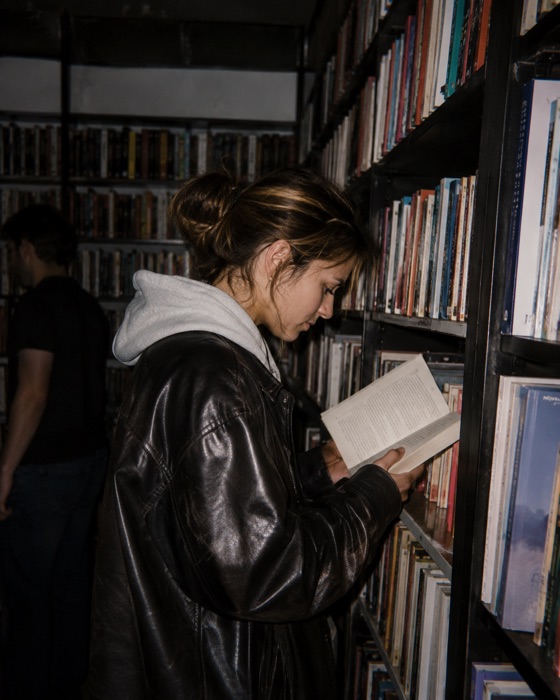 A woman reading beside the shelves in a bookstore