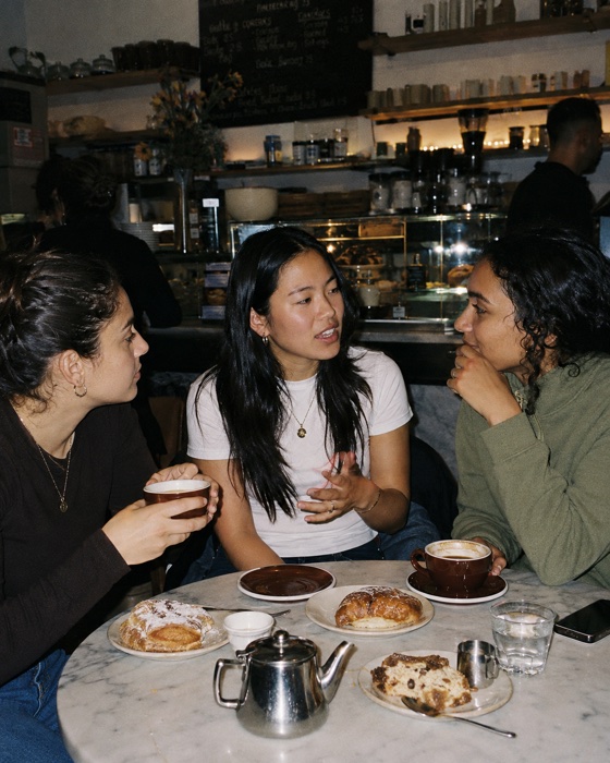 Three friends catching up over coffee and pastries
