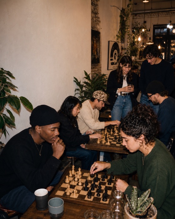 Friends gathered around chess boards in a cosy cafe